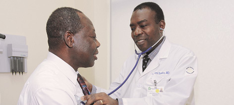 Dr. Abayomi Salako, Chief, Division of Primary Care/Preventive Medicine, examining patient.