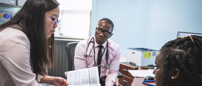 Dr. Gloria Cheung, Attending, Family Medicine, and Dr. Matthew Owolabi, Resident, Family Medicine, counseling patient.