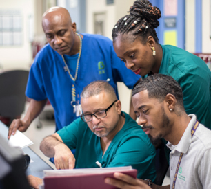 Family Medicine Team Members (standing, L to R): Rudolf Toussaint, RN, and Mary Darko, Nurse Attendant. (Seated, L to R): Jose Saez, Patient Care Technician, and Brandon Salley, Administrative Assistant.