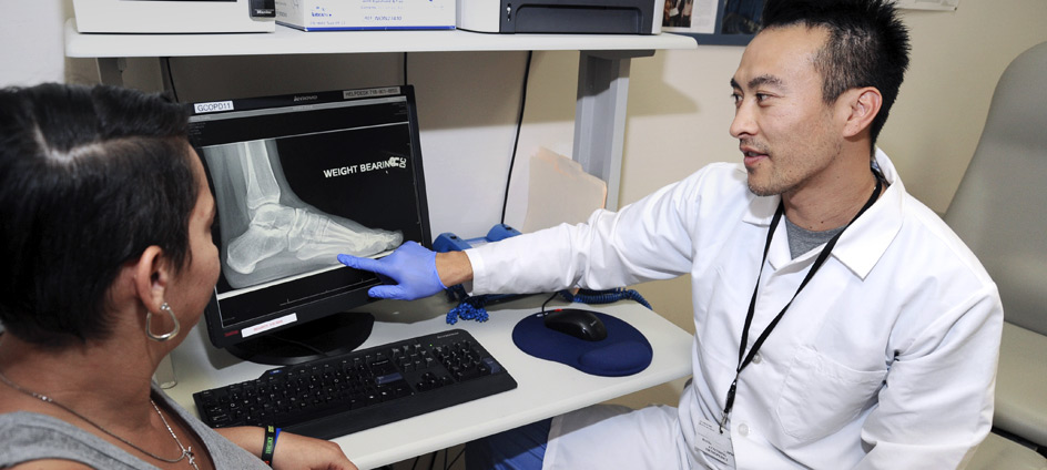 Dr. David Wong, Director, Foot Surgery and Wound Management, Orthopaedics, reviewing foot x-ray with patient.