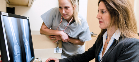 Photo: Dr. Deborah Allen, Attending, Orthopaedics (right), and Kelly Carter, Physician Assistant, evaluating x-ray of patient and developing a treatment plan.