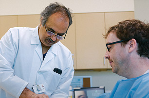 Dr. Hanasoge Girishkumar, Chief, Vascular Surgery, examining patient.