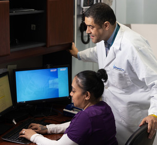 Dr. Jose Tiburcio, Vice Chairman, Family Medicine/Director, Residency Program, reviewing patient information with Alicia Mosquera, Medical Assistant.