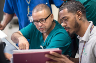 Family Medicine Team Members (standing, L to R): Rudolf Toussaint, RN, and Mary Darko, Nurse Attendant. (Seated, L to R): Jose Saez, Patient Care Technician, and Brandon Sally, Unit Associate.