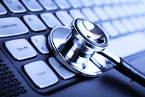 Stock image of stethoscope on computer keyboard